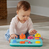 Baby playing with a colorful toy on the floor