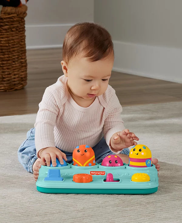 Baby playing with a colorful toy on the floor