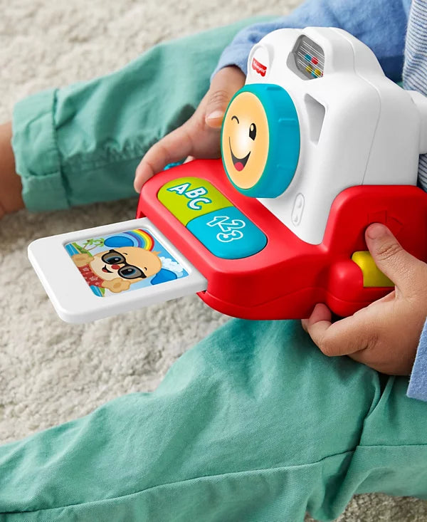 Child holding a colorful toy educational device with a smiling face