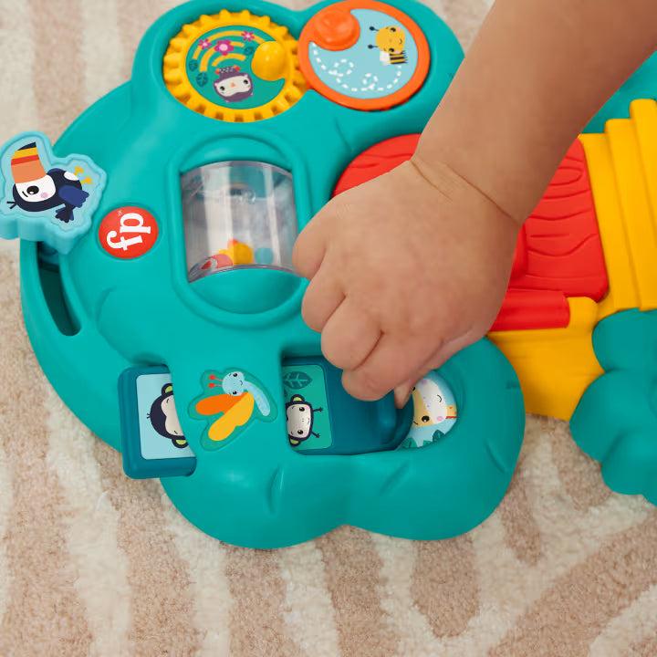 Child's hand interacting with a colorful toy on a carpeted floor