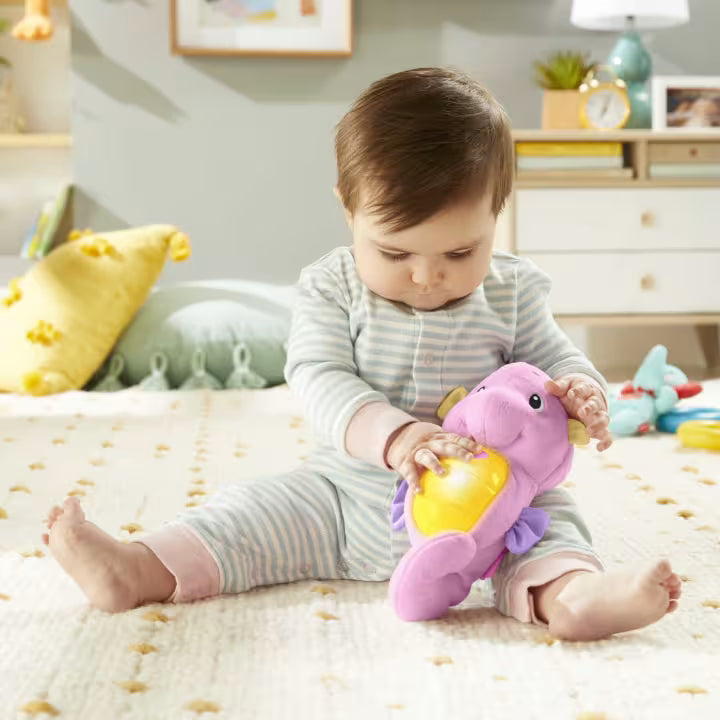 Baby playing with a purple toy in a bedroom setting